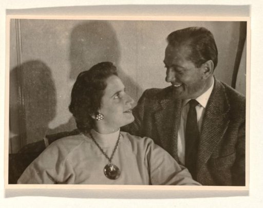 Isabel Wachenheimer with a turtleneck and large pendant and her third husband Gideon Elon, seated and looking at each other, May 1956