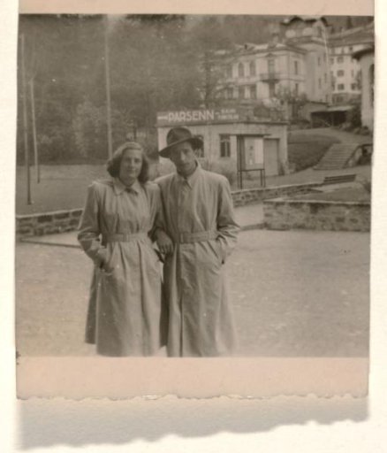 Leo Blumensohn and Isabel Wachenheimer in long coats, standing in front of Parssen and white buildings, Davos 1946