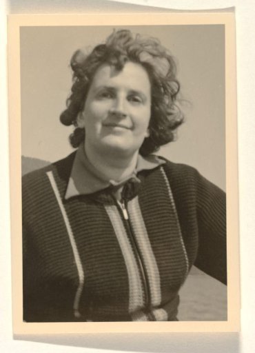 Enlargement of a photograph of Isabel Wachenheimer seated on a bicycle before a lake near a mountain, in dark clothing