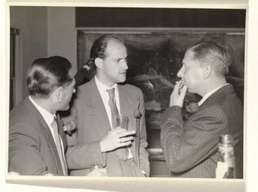 Gideon Elon with a flower in his lapel in conversation with two unknown men, during a reception during Isabel Wachenheimer's time with KLM