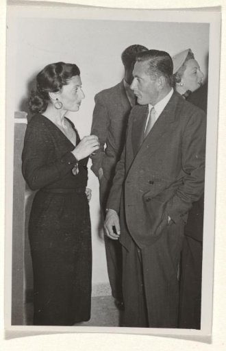 Gideon Elon, the third husband of Isabel Wachenheimer, standing in conversation with an unknown woman
