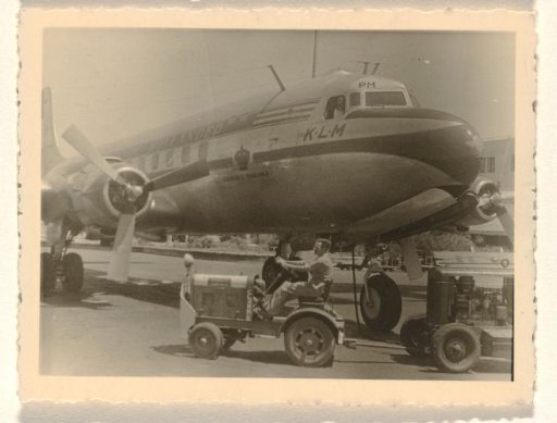 KLM aircraft The Flying Dutchman, with a baggage cart in the foreground for transporting luggage and other items to and from an aircraft