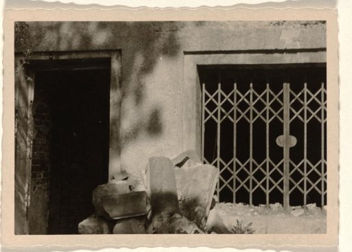 Enlargement of a part of a ruin, with a sliding gate on the right and a doorway on the left