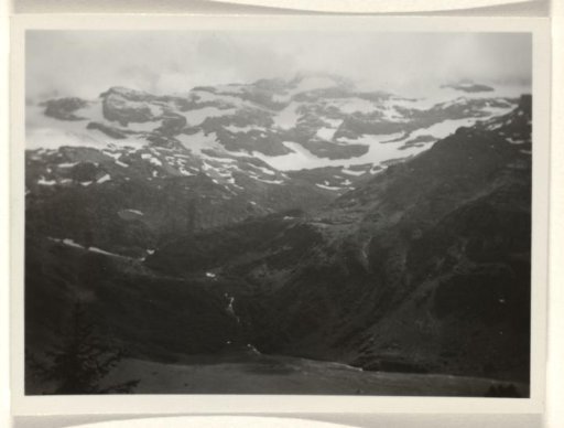 Snowy mountain landscape with a meadow in the foreground