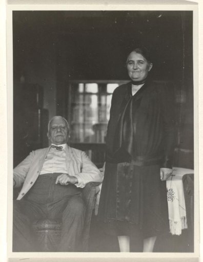 Meir Wachenheimer seated on a chair, with his wife Mathilde Wachenheimer-Wertheimer standing beside him, in a room with a window