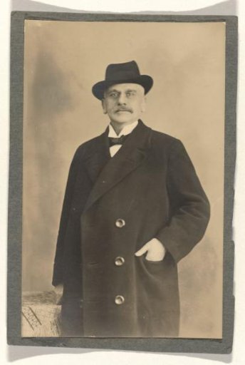 Portrait of Meir Wachenheimer, with a hat on his head and hand in the jacket pocket of a three-button coat
