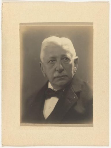 Portrait of Hermann Moos, looking to the right, dressed in a dark suit with a bow tie