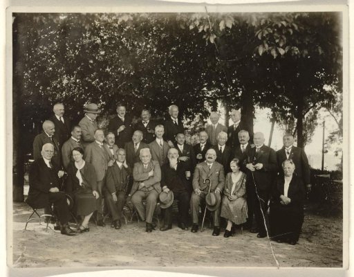 Meir Wachenheimer and unknown people, seated outdoors in a wooded setting