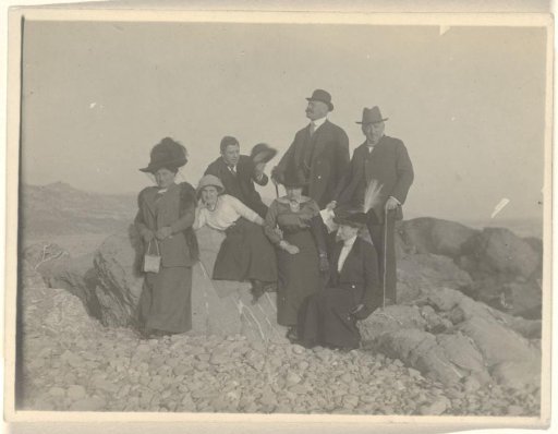 Josefine Moos-Levi, Hermann Moos, Else Wachenheimer-Moos and four unknown people, sitting on rocks in a desert-like rocky landscape