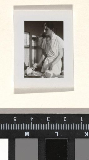 Member of the household staff of the Wachenheimer family, possibly the nursemaid, standing by a table with two teapots