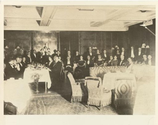 Eugen Wachenheimer and his wife Else Wachenheimer-Moos in evening wear in a hall with unknown persons