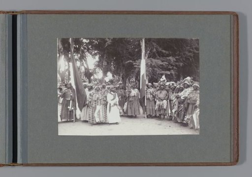 Group of Surinamese women in kotomisi; two women carry a flag