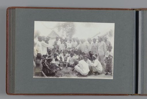 Group of men – some sitting and some standing, playing a game