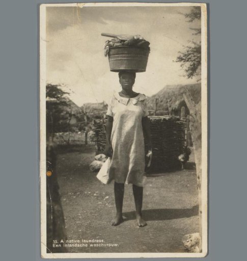 Portrait of a woman with a laundry basket on her head in Curaçao