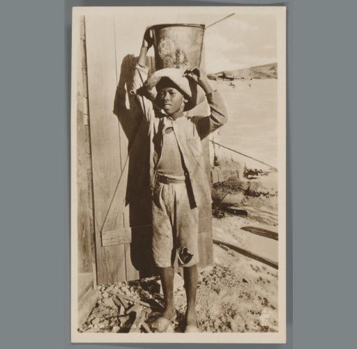 Boy with a water bucket in Aruba