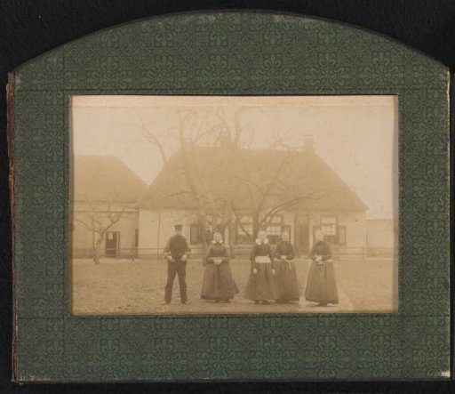 Four women and a man in front of a house