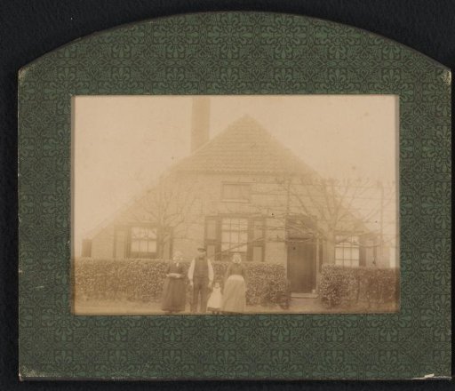 Four persons in front of a house