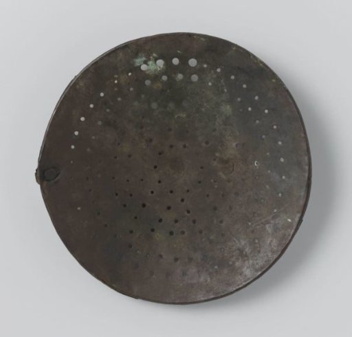 Sieve of a copper foam pan with holes in the shape of two concentric circles and a six-pointed star