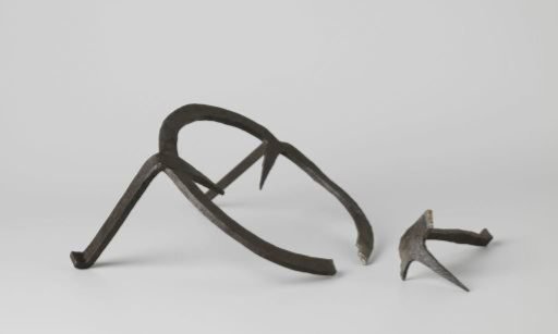 Trivet, ring-shaped with three pointed feet curving downward