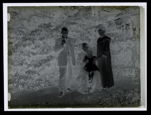Group portrait of an unknown man, two women, and a child in a garden