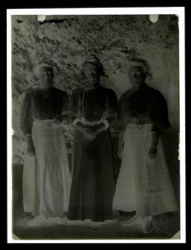 Group portrait of three unknown women in a garden