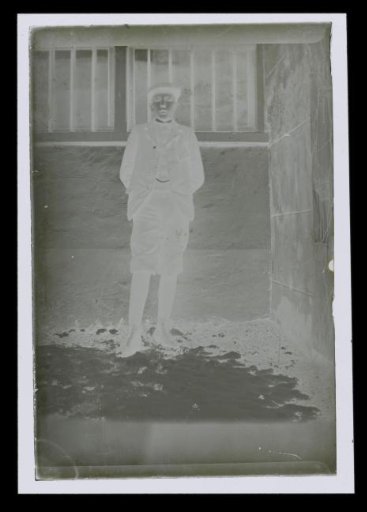 Portrait of an unknown boy, standing in front of a wall