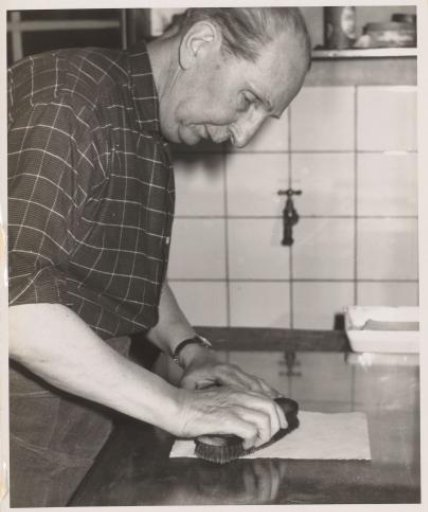 Jan Poortenaar brushing a sheet of paper with an inking brush