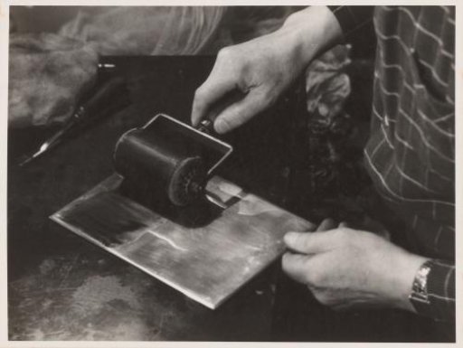 Jan Poortenaar rolling an etching plate with ink
