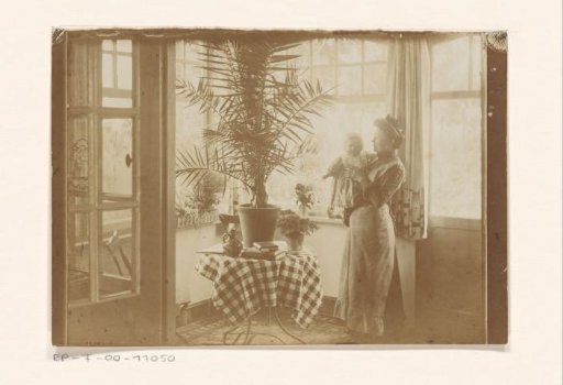 Woman with a baby in her arms in a greenhouse