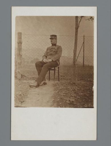 Portrait of an Unknown Man in Uniform Sitting Outside on a Chair, Presumably a Watchman