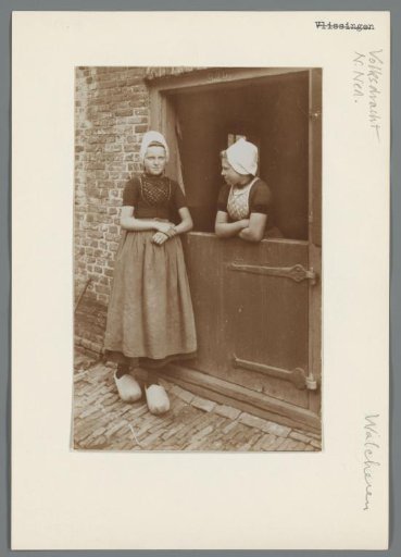 Two girls in Walcheren costume beside a stable door