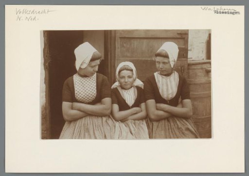 Three girls in Walcheren costume with arms folded