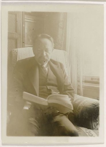 Andries Bonger, in an armchair, reading a book