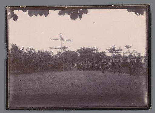 Road with walking people in a village, Dutch East Indies