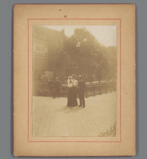 Group portrait of an unknown man, woman and child on a canal