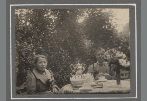 Portrait of two unknown women at a table with coffee or tea