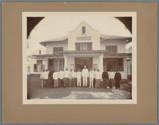 Group portrait of unknown Indian and European men in front of a building of the Landraad, Dutch East Indies