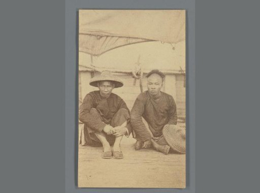 Portrait of two unknown Chinese men sitting on a ship