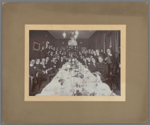 Group portrait of unknown young men, probably students, at a set table