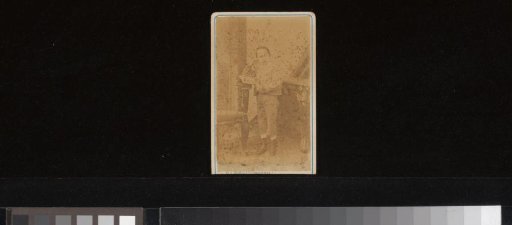Portrait of a boy with an open book by a chair