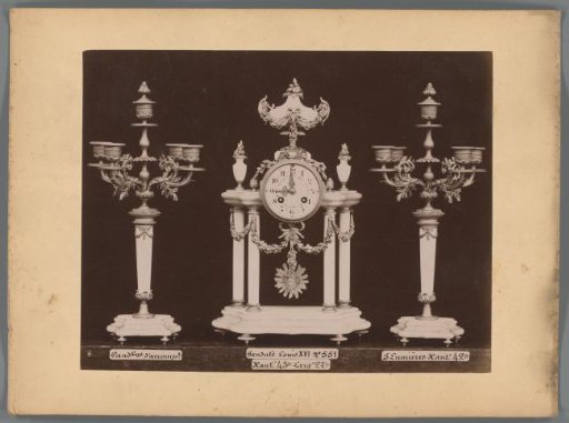 Photographic reproduction of two candlesticks and a clock