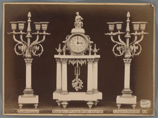 Photographic reproduction of two candlesticks and a clock