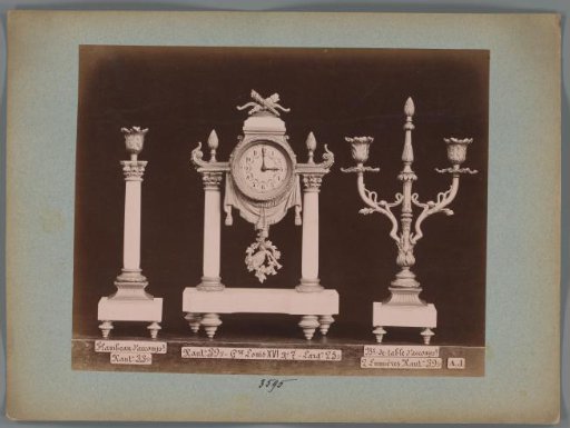 Photographic reproduction of two candlesticks and a clock