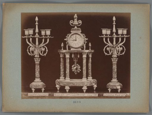 Photographic reproduction of two candlesticks and a clock