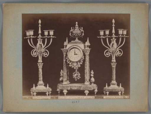 Photographic reproduction of two candlesticks and a clock