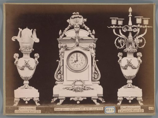 Photographic reproduction of a lamp or vase, clock, and candlestick