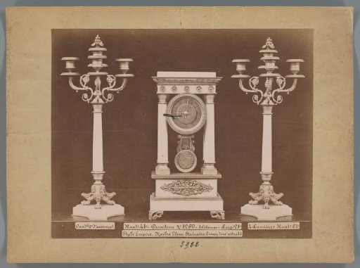 Photographic reproduction of two candlesticks and a clock in Empire style with marble columns