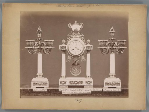 Photographic reproduction of two candlesticks and a regulator clock with marble