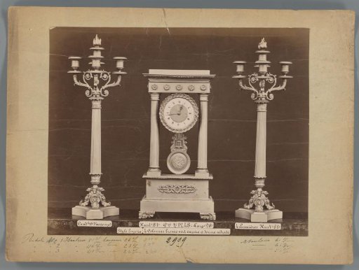 Photographic reproduction of two candlesticks and a clock with bronze columns