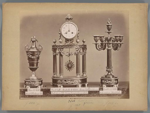 Photographic reproduction of a vase, regulator clock with bronze and four columns and a candlestick